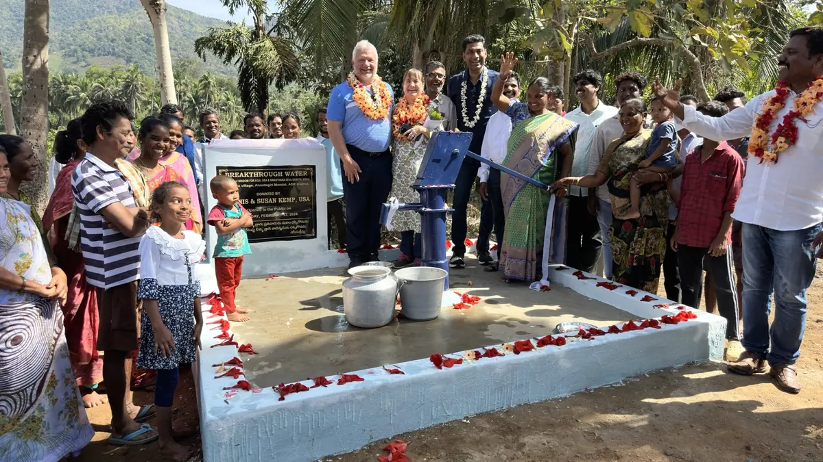 Community members and project partners gather around a completed Breakthrough Water hand pump.